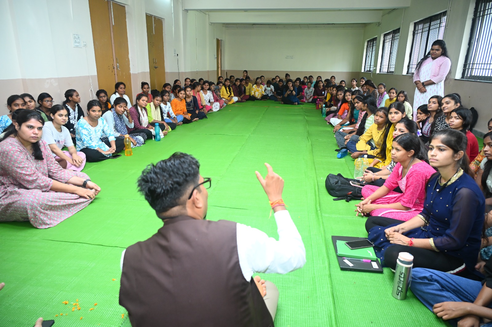 A girl presenting her work, in English, in front of her cohort.